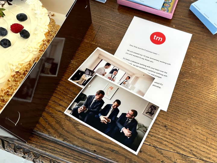 Image of a cheesecake in a pastry box, alongside a wedding photograph of 3 men in suits